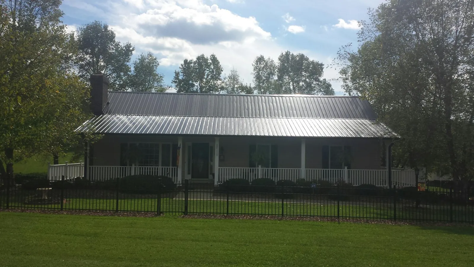 Gray metal roof on a brick ranch with a full width front porch — Gutter Guard Installation work by our crew in Good Hope